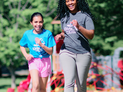 Adult and GOTR participant running together. 